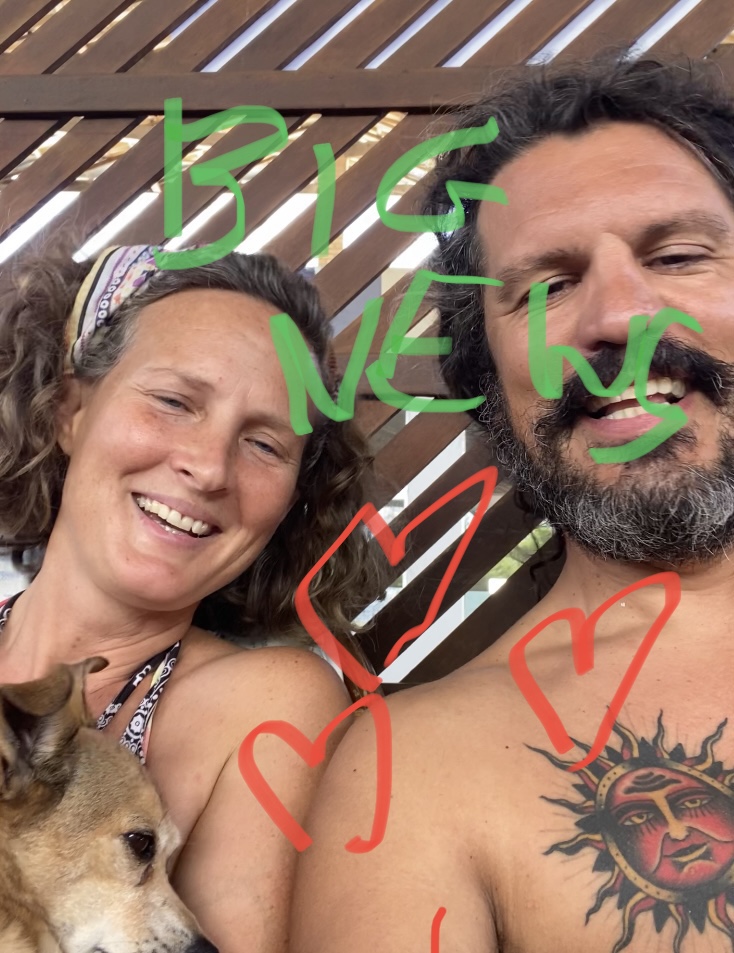 A woman (Kay) and a man (Dimi) and a dog (Coco) with handwritten in green BIG NEWS and red hearts